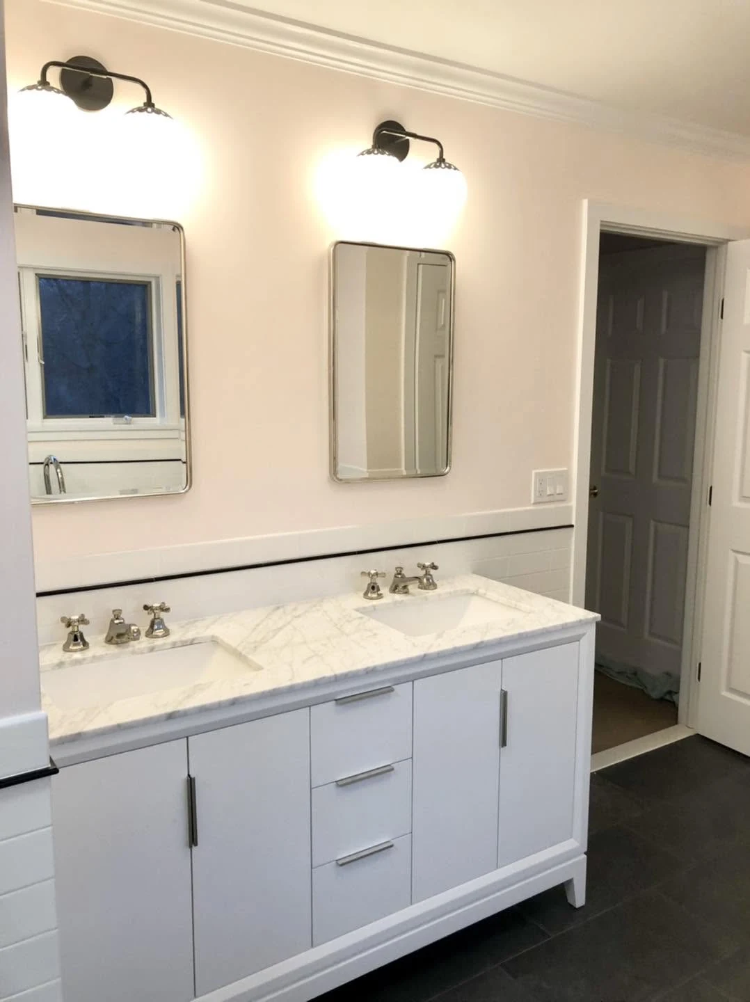 Renovated bathroom with a double vanity and wall mirrors