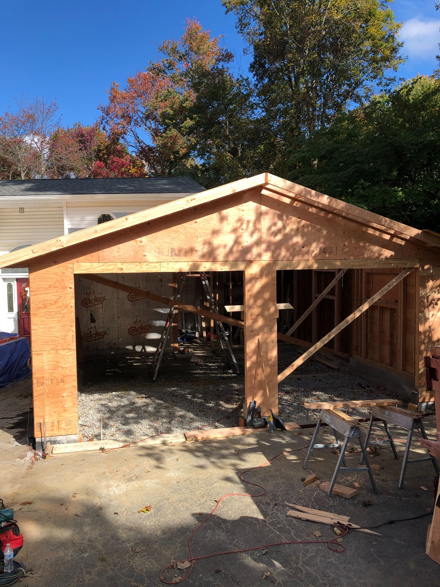 Garage addition framed beneath a blue autumn sky
