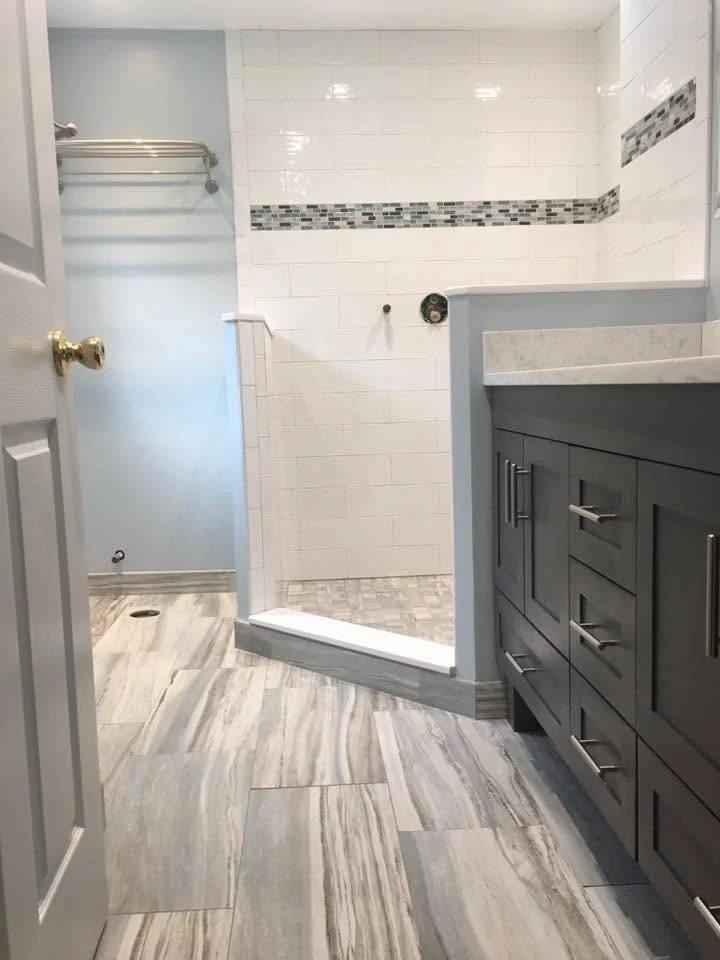 Renovated bathroom with vanity and tiled shower